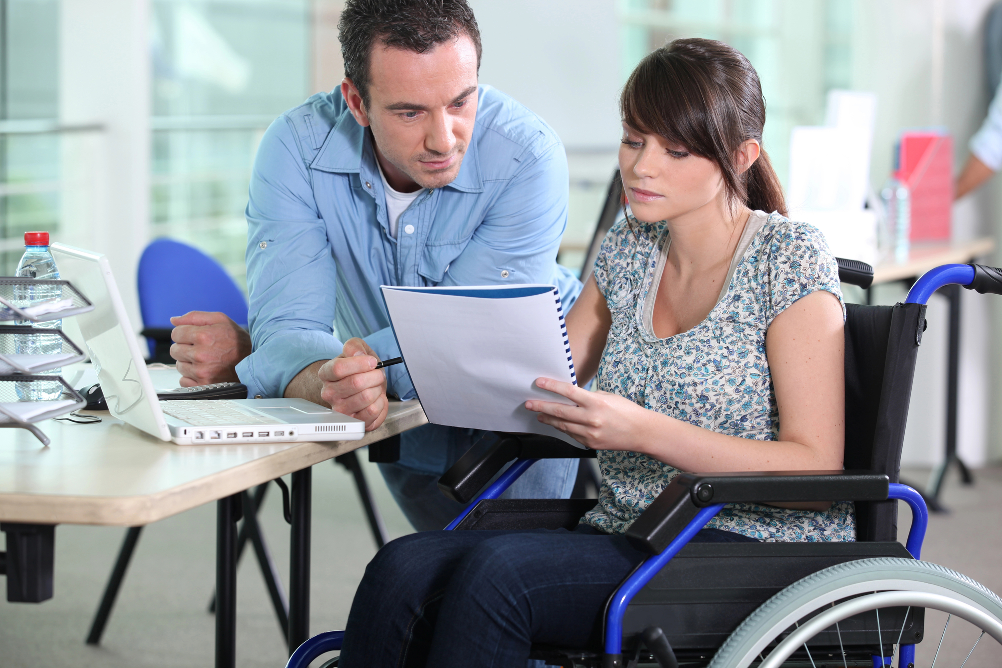 Man and woman in a wheelchair looking at E2 visa documentation